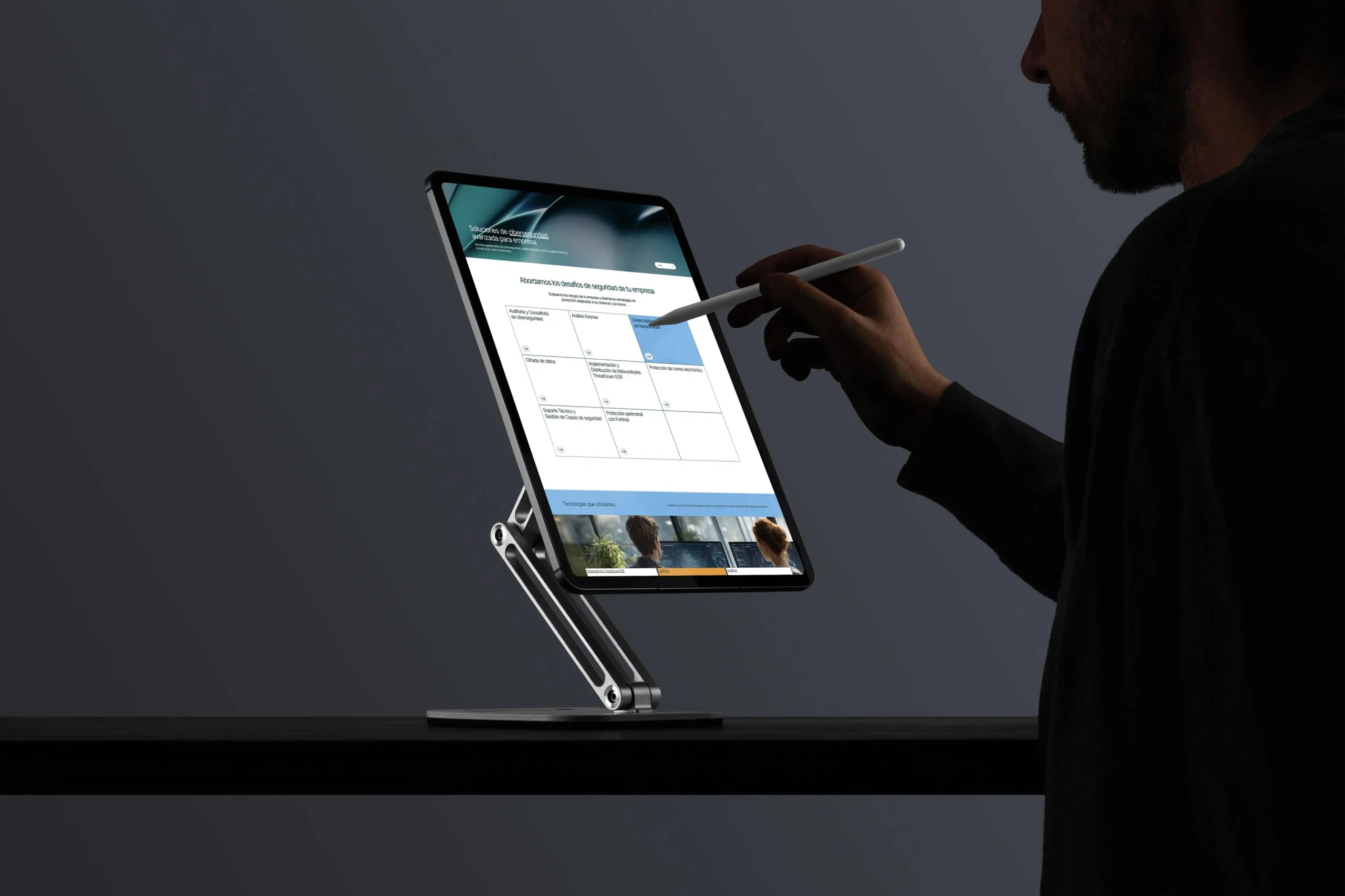 Hombre usando un lápiz óptico sobre una tablet en un soporte que muestra la web de soluciones de ciberseguridad para empresas de Antimalwares, fotografía realizada por DonDigital.