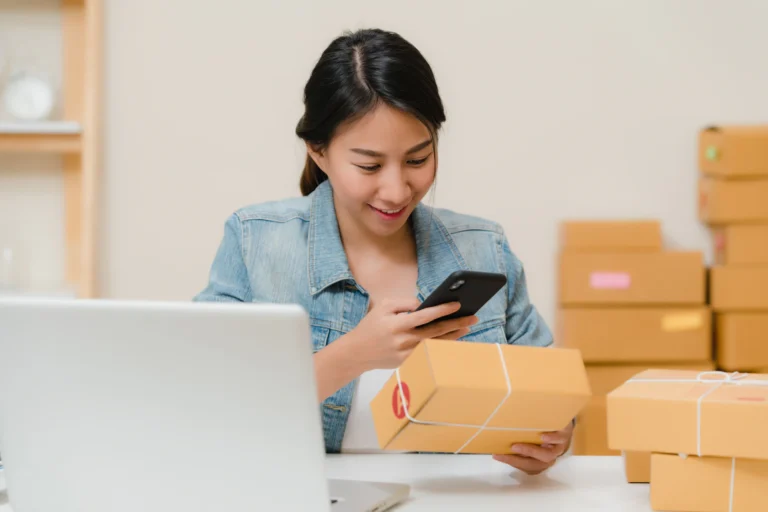 Dueña de una tienda online preparando pedidos entre cajas de envío