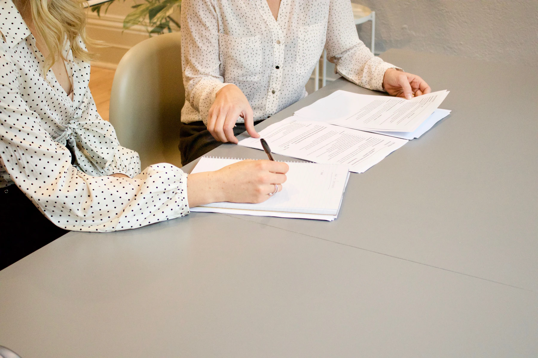 Asesora revisando y firmando documentación de protección de datos con una empresa